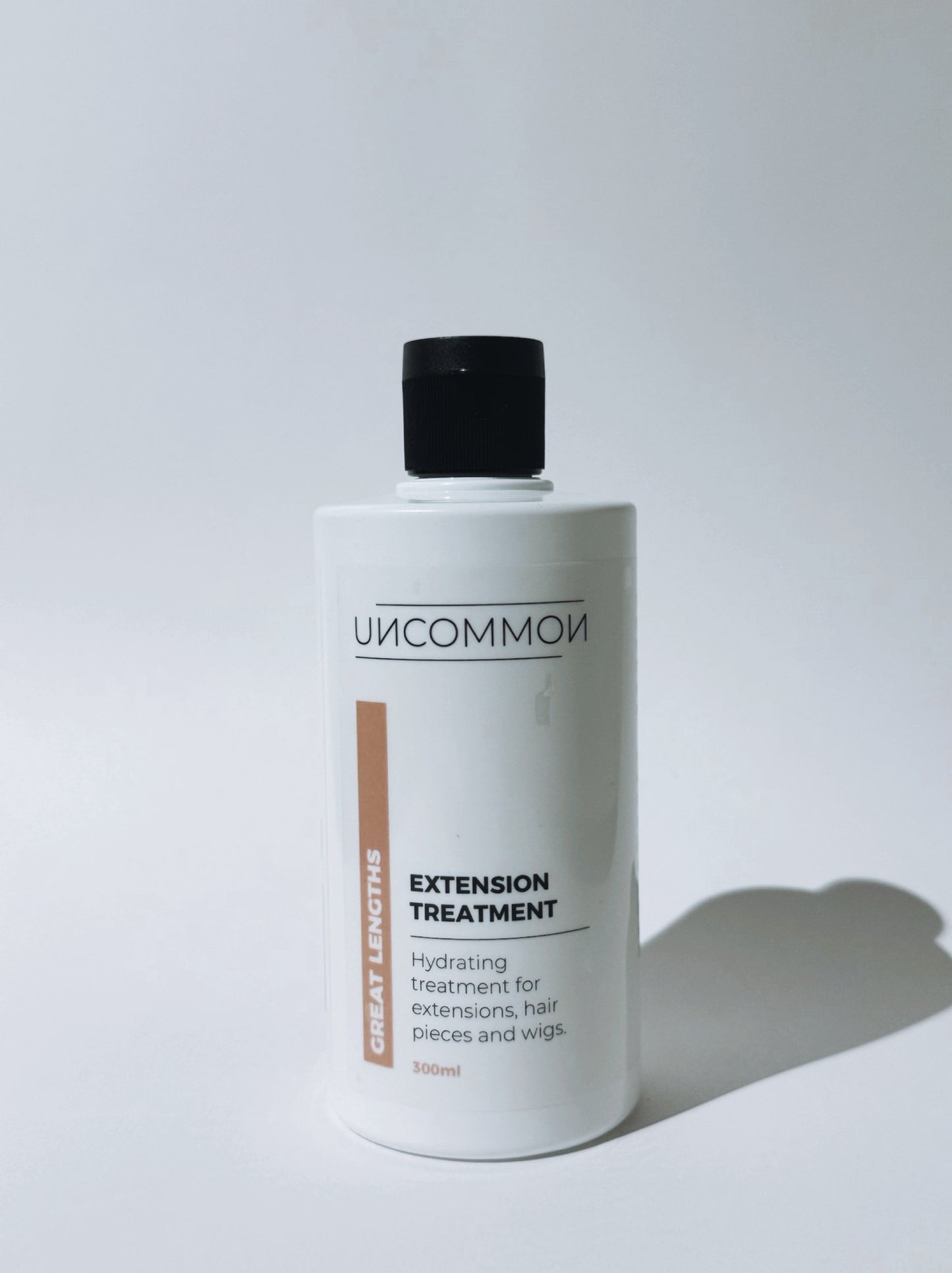 Bottle of 'Uncommon' extension treatment on a white background