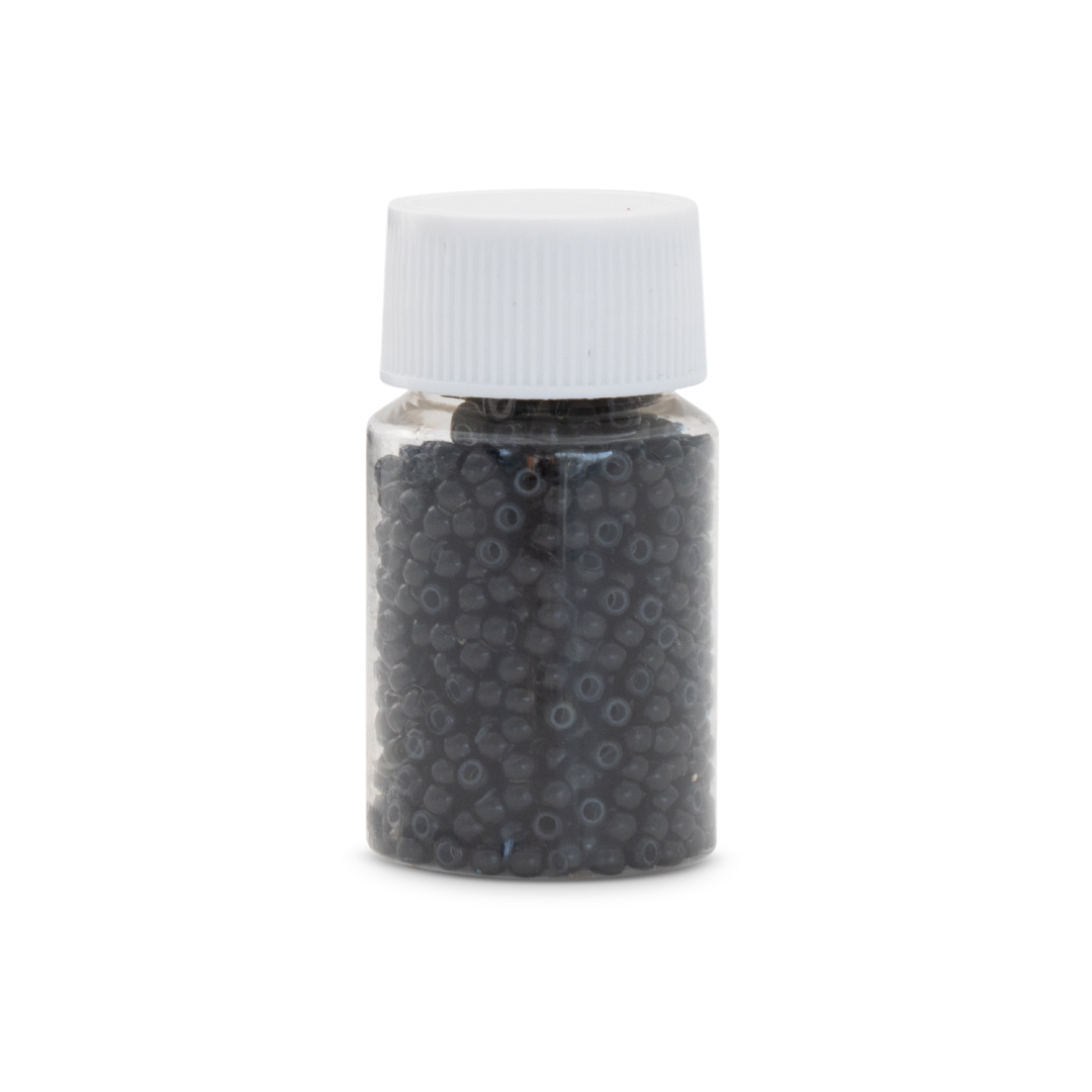 Small jar with black beads and a white lid on a white background