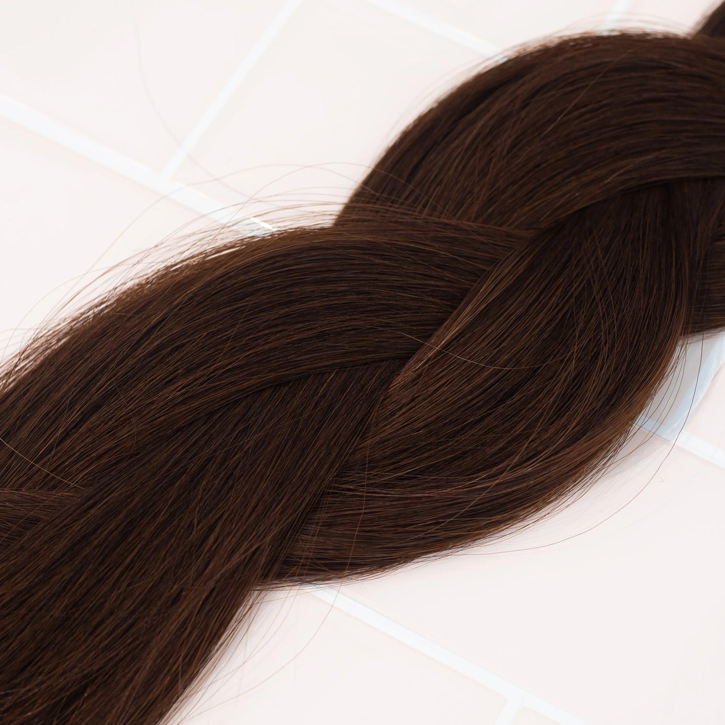 Loxys Coco weft extensions, braided on a neutral background