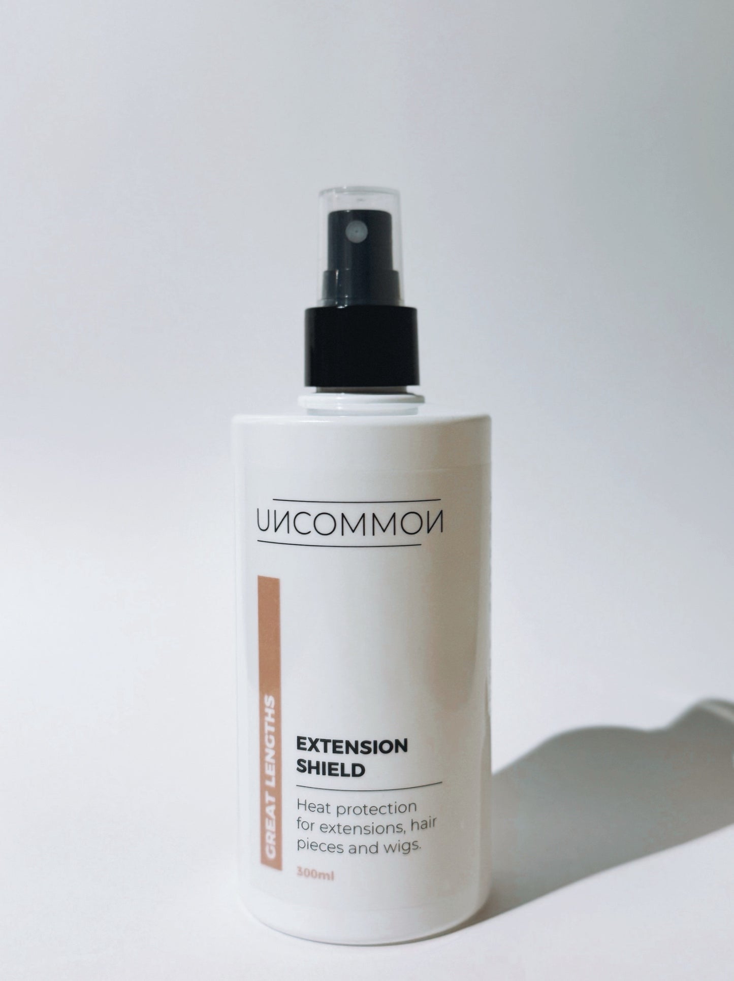 Bottle of 'Uncommon' Extension Shield on a white background