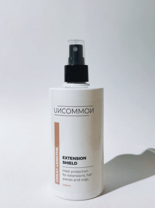 Bottle of 'Uncommon' Extension Shield on a white background