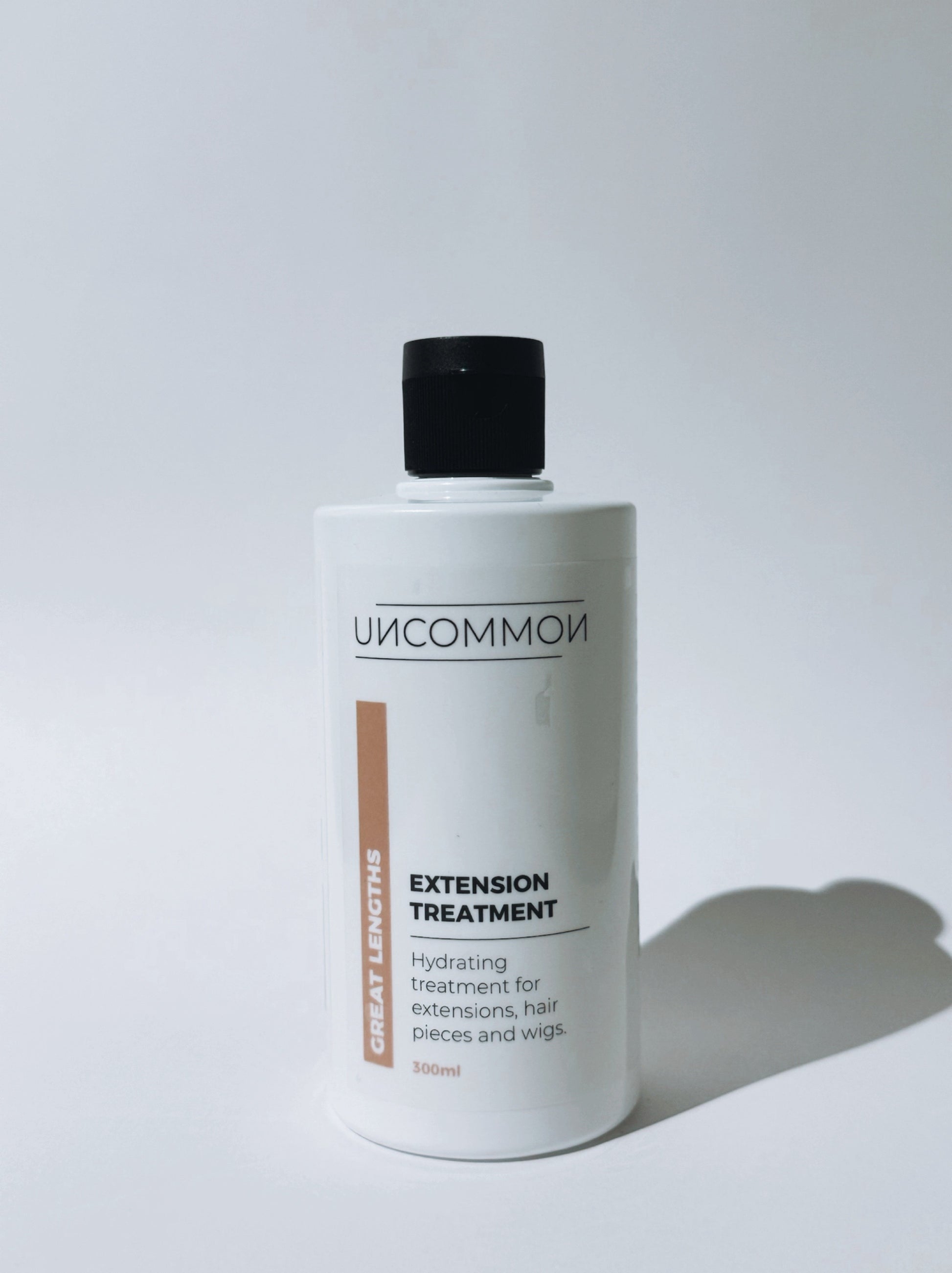 Bottle of 'Uncommon' extension treatment on a white background