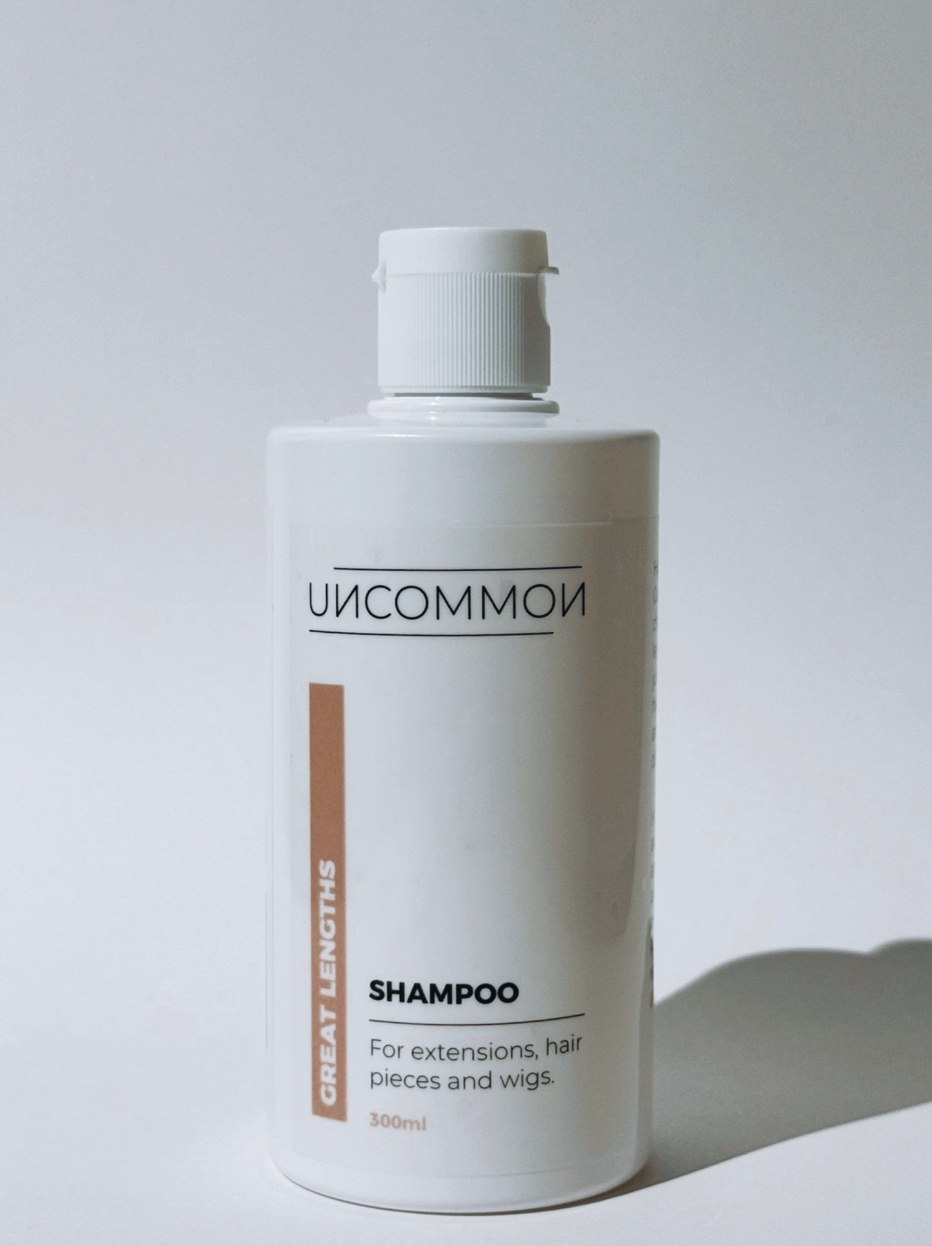 Uncommon shampoo bottle for extensions on a white background