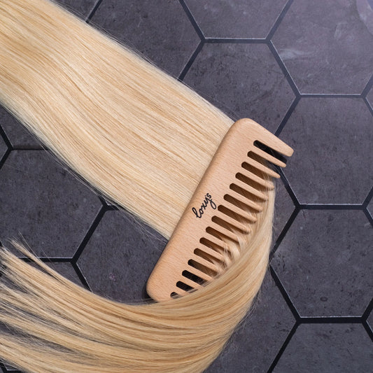 Close up of Loxys Vanilla weft on a dark tile background with a wooden comb