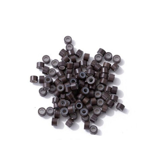 A collection of brown micro rings with soft silicon insert scattered on a white surface.
